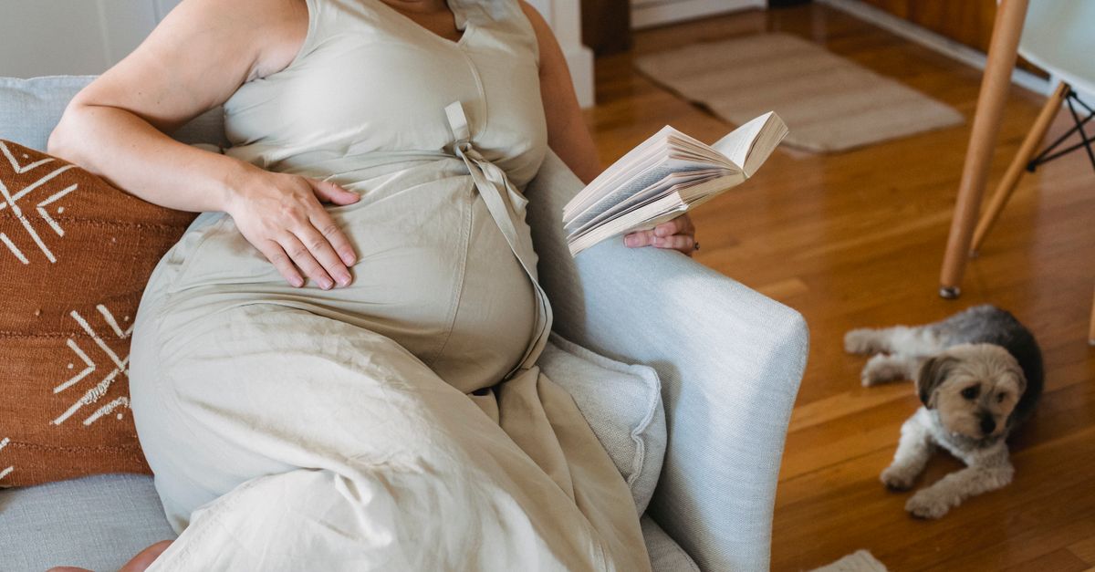 Gestante relaxada com a mão na barriga, em um momento de autocuidado